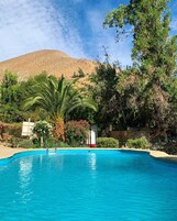 Una piscina al aire libre, camas de piscina gratis, sombrillas