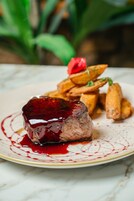 Un plato con un guiso de carne y patatas asadas.