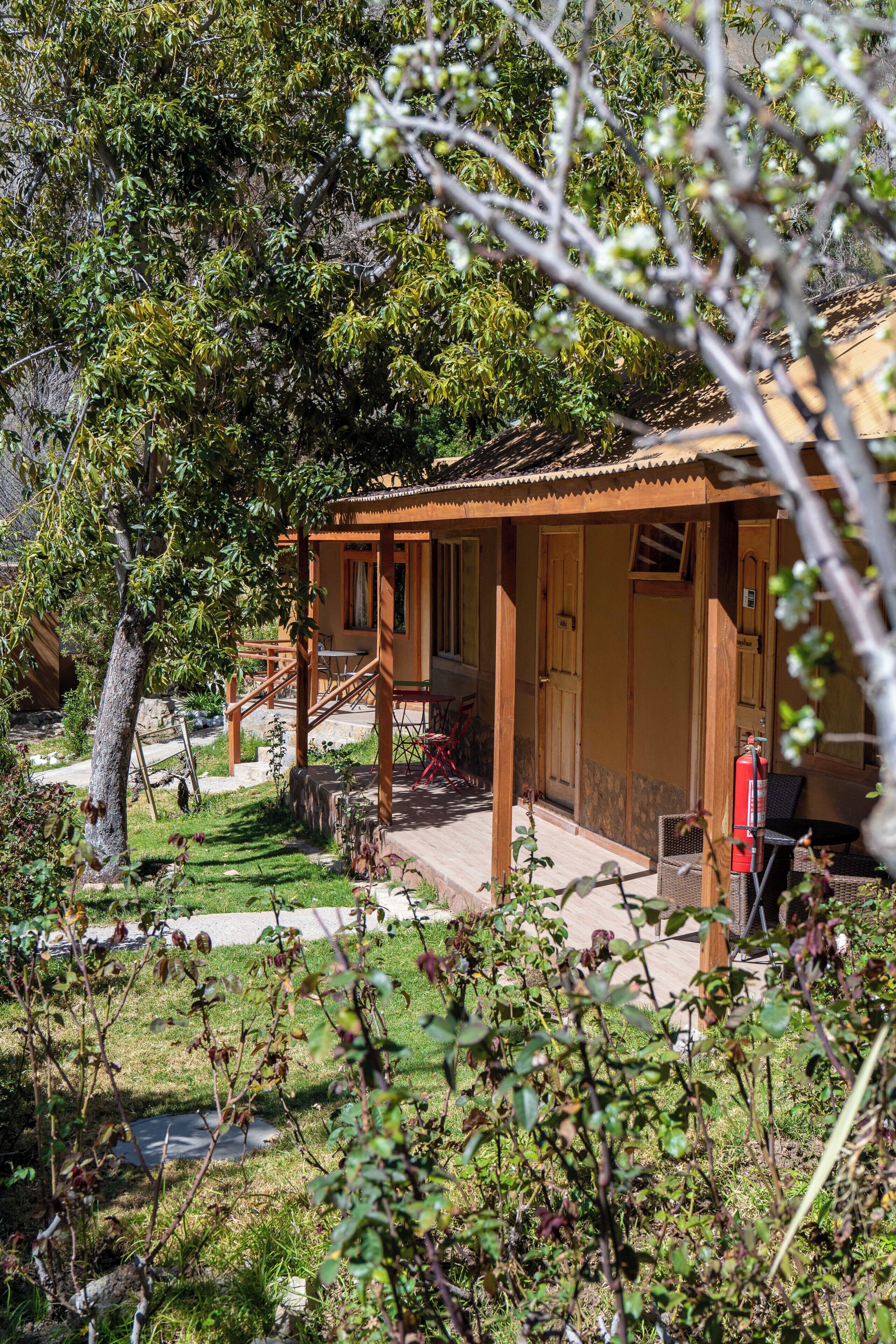 Eine Holzhütte mit Veranda, Feuerlöscher und Tisch.