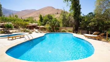 Una piscina al aire libre, cabañas de piscina gratuitas, sombrillas