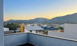 A residential area with buildings and mountains in the background. - Casa Comfort Rio Vermelho - Florianópolis (Florianópolis)