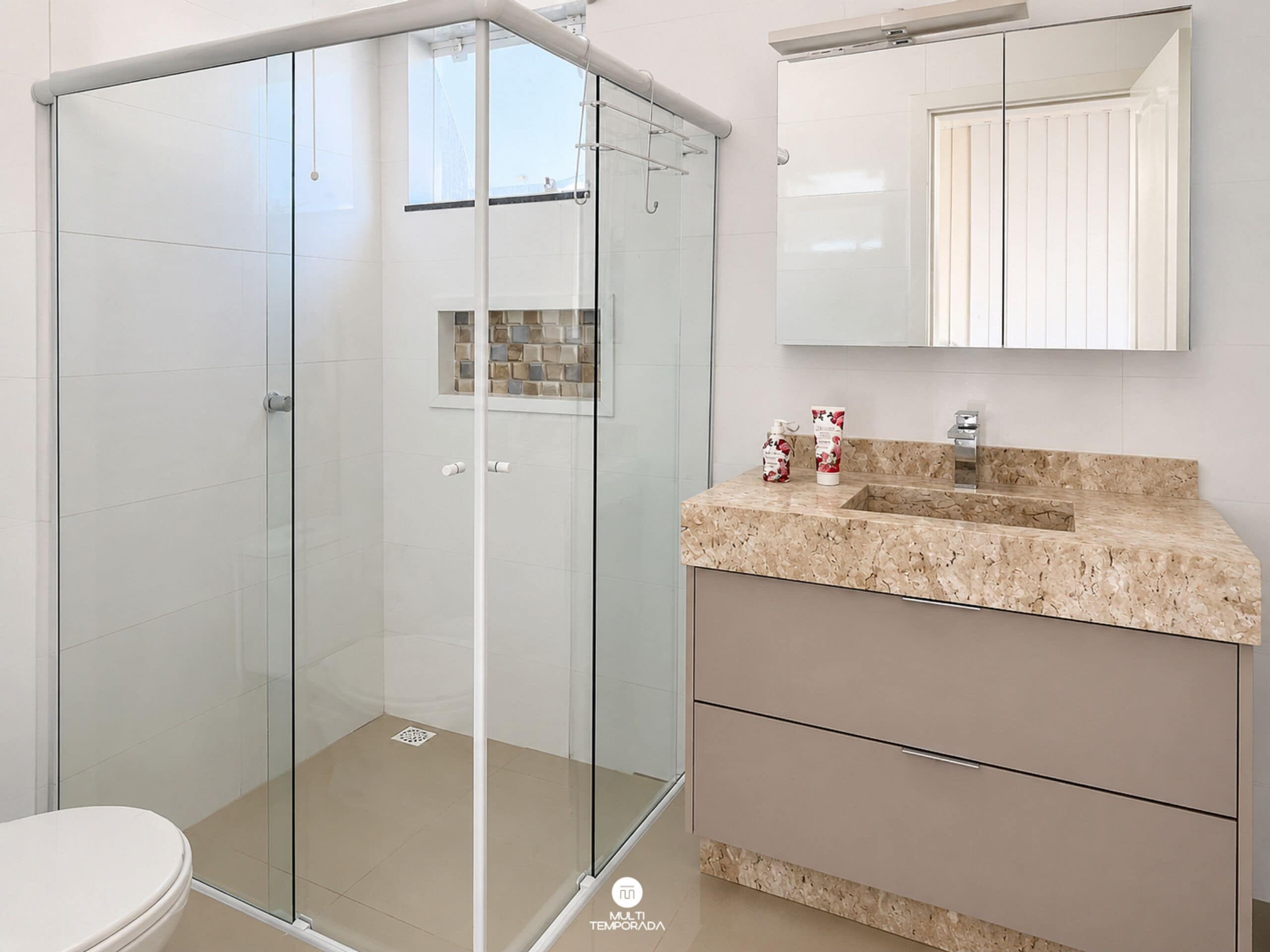A modern bathroom with a glass-enclosed shower, a beige marble countertop, and a large mirror above the sink.