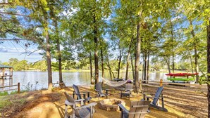 Un terrain de camping au bord du lac, équipé de chaises Adirondack, d’un foyer et d’un hamac.