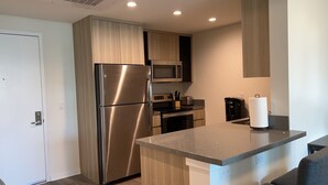 A modern kitchen with stainless steel appliances, wooden cabinets, and a granite countertop. - Spacious & Modern 1BedRM in Noho (Burbank)