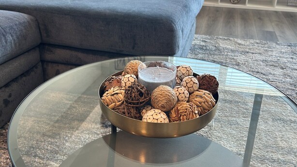 A living room with a glass coffee table holding a bowl of cookies and a candle. - Spacious & Modern 1BedRM in Noho (Burbank)
