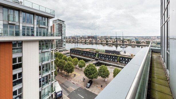 Een modern hotel met een glazen gevel met uitzicht op een rivier.