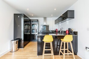 Enjoy cooking in this well-equipped kitchen with a central island, stainless steel appliances, and ample seating.