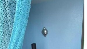 A staircase with a black railing and wooden steps, a blue wall, and a metal light fixture. - Piso Bolnuevo Playa, muy Cerca de la Playa, al Lado Todos los Servicios, (Bolnuevo)