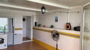 A kitchen with a washing machine, a fan, and a radio on the counter. - Piso Bolnuevo Playa, muy Cerca de la Playa, al Lado Todos los Servicios, (Bolnuevo)