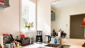 Una cocina moderna con horno integrado, cafetera y fregadero.