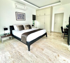 A bedroom with a bed, bedside tables, a wardrobe, and a desk.