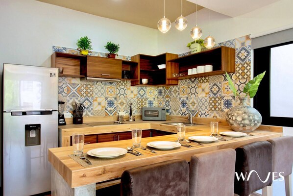 Una cocina moderna con una isla central, armarios de madera y salpicadero azulejado.