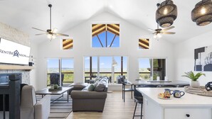A spacious living area with a fireplace, a sofa, a dining table, and a kitchen area. - Grand Lake View with Outdoor TV, Fireplace, Hot Tub & Game Room Free Attractions Tickets_Cmty Pool (Kimberling City)