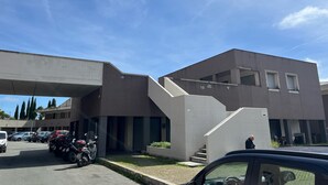 A modern building with a flat roof, a staircase leading to an upper level, and a parking area with several cars and motorcycles. - Nice Apartment With sea View in Genoa (Genoa)