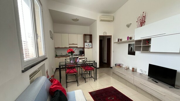 A compact living space with a kitchenette, a dining area, and a seating area with a sofa and chairs. - Nice Apartment With sea View in Genoa (Genoa)