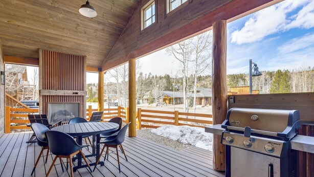 A covered outdoor deck with a grill, chairs, and a table. - Mountain Views: Luxurious Grand Lake Escape! (Grand Lake)