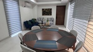 Un comedor moderno con una mesa redonda rodeada de sillas, un sofá y una mesita de centro.
