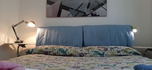 A bedroom with a bed, two bedside lamps, a patterned pillow, and a wall-mounted abstract painting. - Relax - Olive And Sea Sperlonga (Itri)