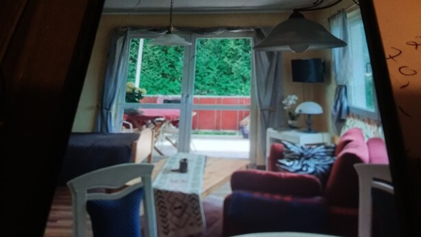 Ein Zimmer mit Esstisch, Stühlen, einer Couch und einem Fernseher.