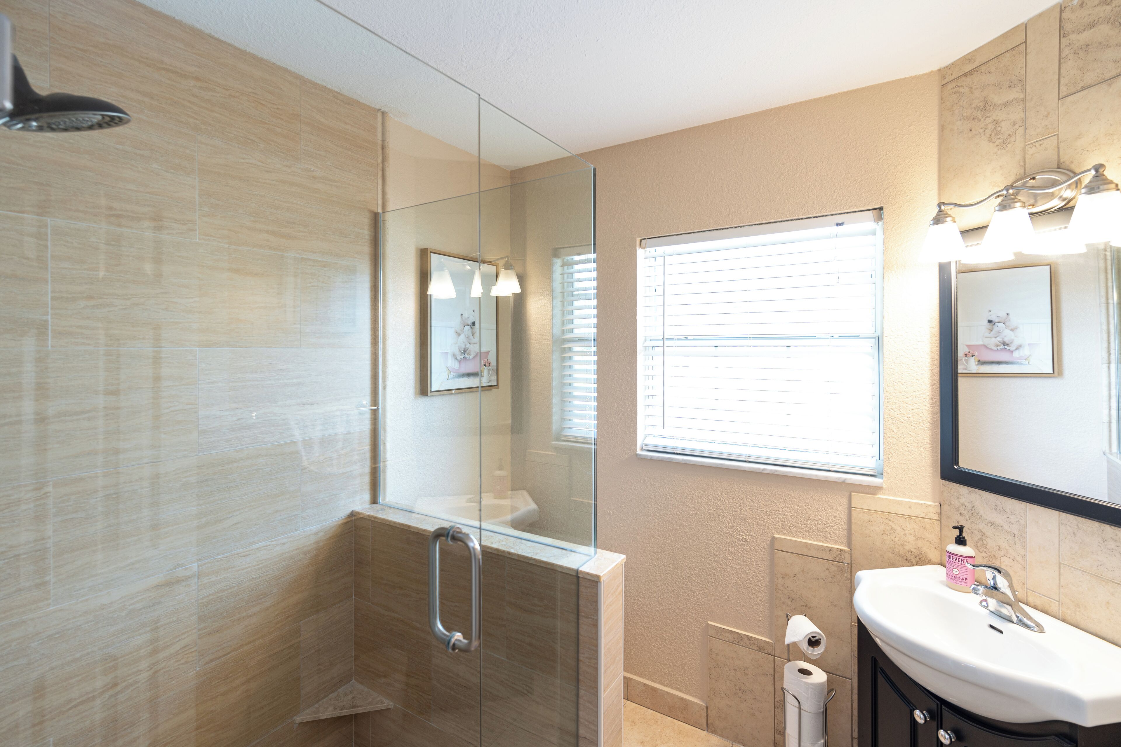 Une salle de bain moderne avec une douche à parois de verre, un meuble-lavabo et un grand miroir.