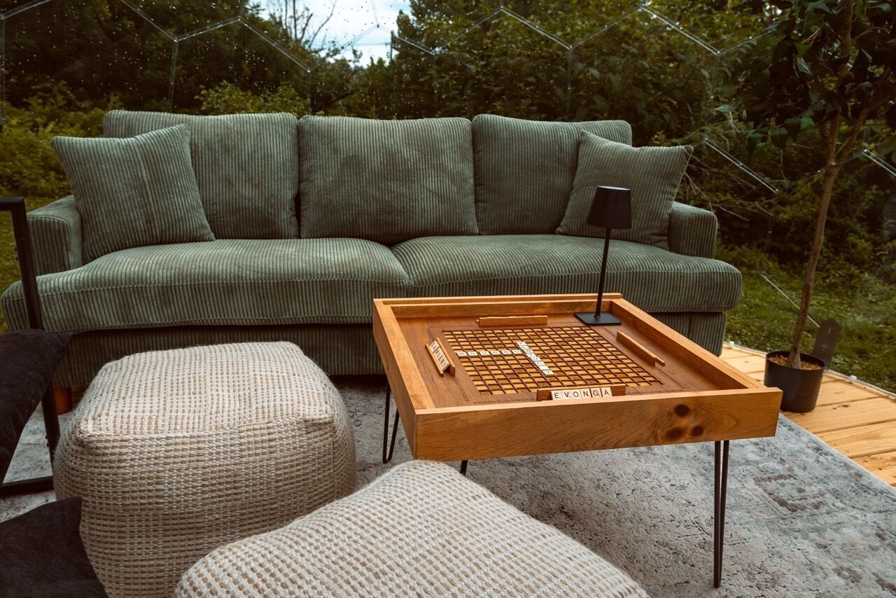 Ein grünes Sofa mit einem Holztisch für Brettspiele davor.