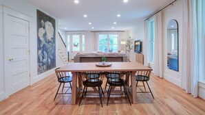 A spacious room with a wooden dining table and chairs, a large bed with a view to the outdoors, and a staircase leading to another level. - LUX Waterside Retreat with Geo Dome + Outdoor Fire Table, Historic Property (Prospect)