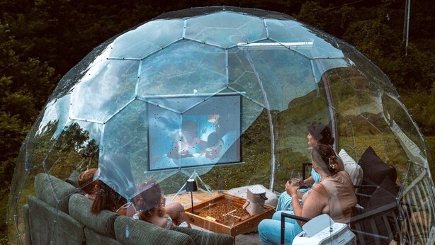 A transparent dome structure with a wooden deck, seating, and a television. - LUX Waterside Retreat with Geo Dome + Outdoor Fire Table, Historic Property (Prospect)