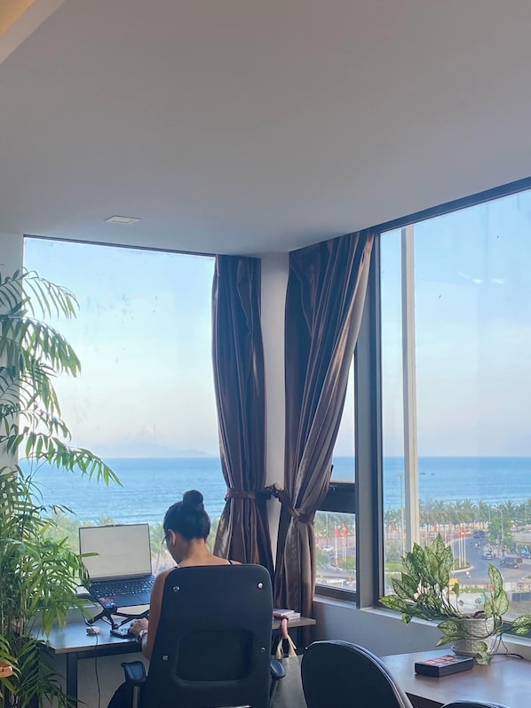 A room with a large window, a desk, and a chair.