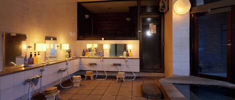A modern bathroom with a large mirror, multiple sinks, and a shower area.