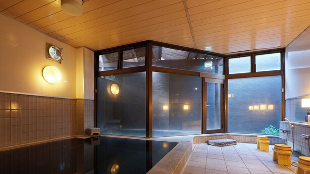 A modern indoor pool with clear glass walls, a wooden ceiling, and a tiled floor. - Tabist Sakura no Yakata Hotel (Fuefuki)