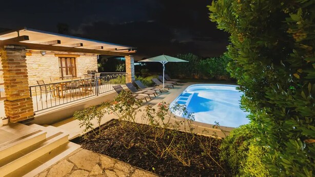 A stone building with a pool, outdoor seating, and a covered patio area. - Jurinea in Vi Njan With 4 Bedrooms and 2 Bathrooms (Visnjan)