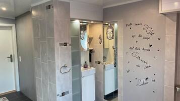A modern bathroom with a glass partition, a white sink, and a mirror.