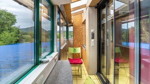 Un interior moderno con ventanas amplias, un banco y una silla.