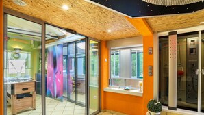 Un interior moderno con techo de madera, puertas correderas de vidrio, un lavabo y zona de ducha.