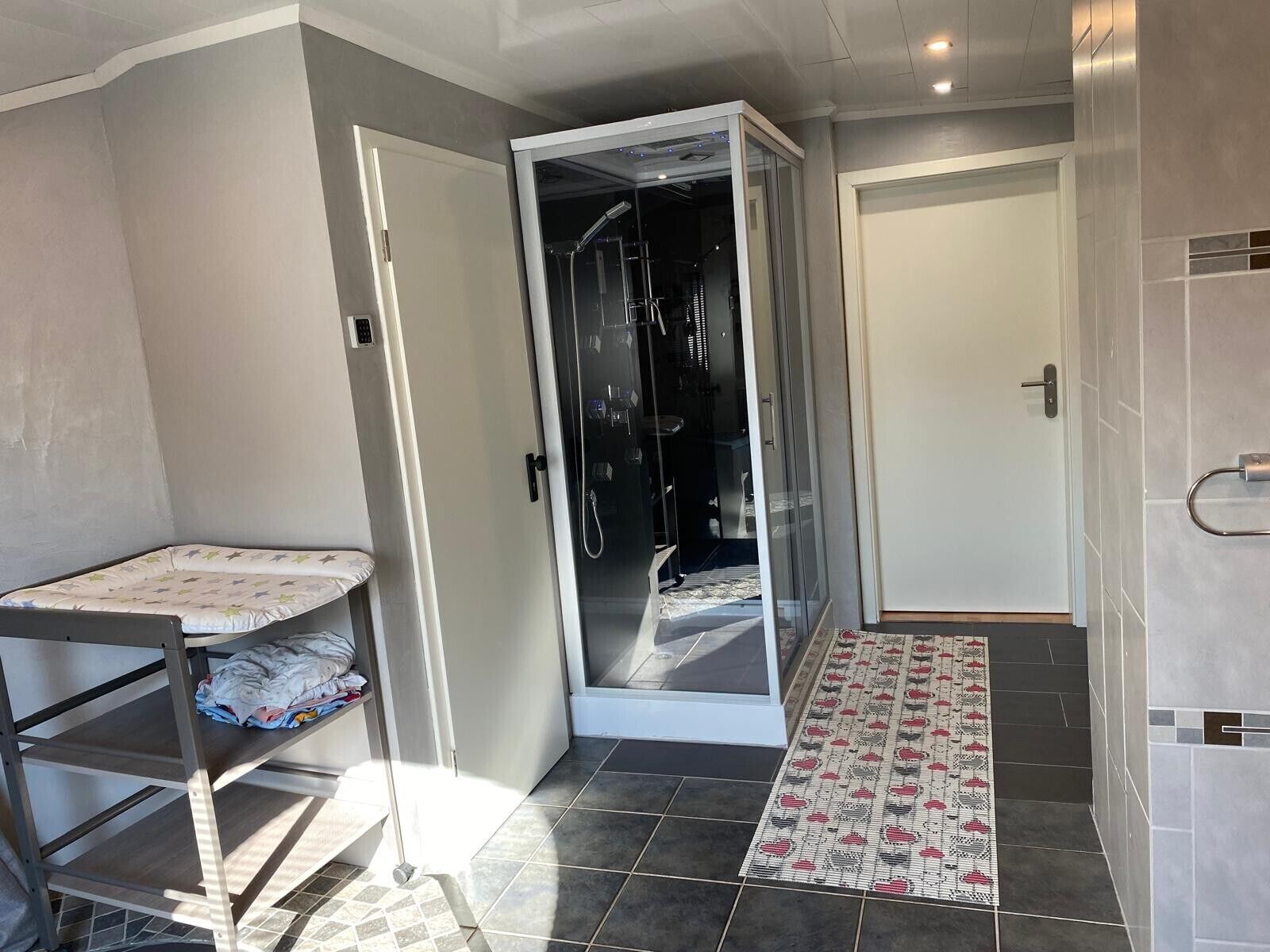 Une chambre comprenant un lit, un espace douche et un petit coin salon.