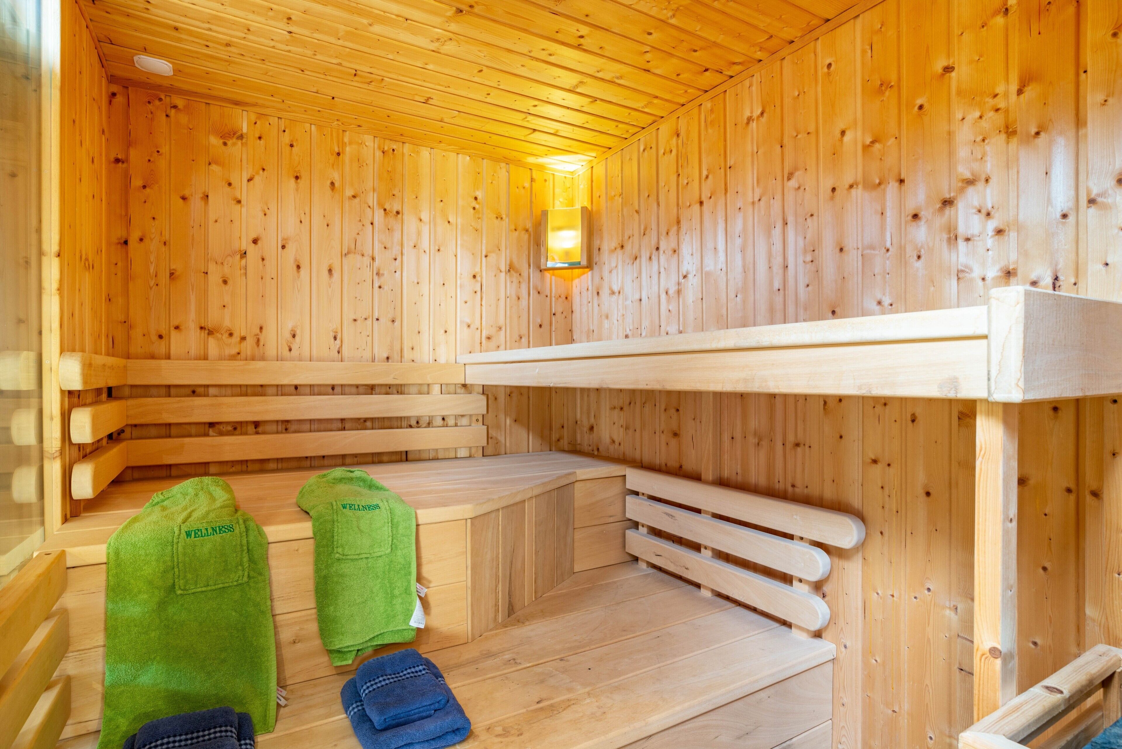 A wooden sauna with benches, a bench, and a towel rack.
