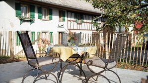 A patio with a table set for two, surrounded by metal chairs. - Holiday Apartment "Morgentau" with Private Terrace & Wi-Fi (Heiligenberg)