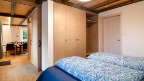 A bedroom with a bed, wooden wardrobe, and a desk area. - Holiday Apartment "Morgentau" with Private Terrace & Wi-Fi (Heiligenberg)