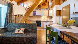 Un interior acogedor con sofá, mesa de comedor y zona de cocina.