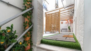 A narrow outdoor space with a wooden gate, a small table, and a chair. - Apartment "Aurisa" with Private Terrace & Wi-Fi (Bari)
