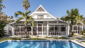 A modern house with a swimming pool, surrounded by palm trees and a well-maintained lawn. - Walk to the beach & restaurants @ Las Terrenas for 10! (Las Terrenas)