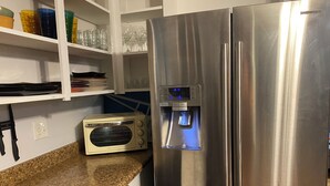 A stainless steel refrigerator with a water dispenser and a built-in radio.