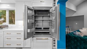 A modern kitchen with white cabinetry and a built-in refrigerator. - 6 Bed High End Home w/ EPIC Backyard! (Arlington)