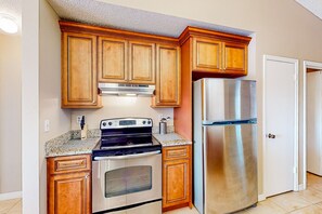 Kitchen features a double oven, microwave, and refrigerator, with classic cabinetry and granite countertops.