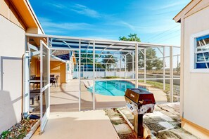 Enjoy a patio with a clear view of the backyard pool and garden, perfect for outdoor dining and relaxation.