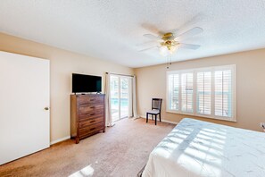 Relax in this serene bedroom with a large bed, flat-screen TV, and comfortable chair.