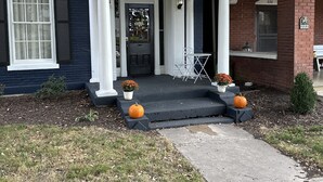 A two-story house with a porch, numbered 220 and 222, and a small garden with pumpkins. - The Indigo House- Located in the heart of Historic Hannibal, Missouri  (Hannibal)