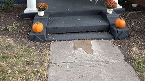 A front porch with a black door, white columns, and a number '220' above the door. There are two potted plants on either side of the steps. - The Indigo House- Located in the heart of Historic Hannibal, Missouri  (Hannibal)