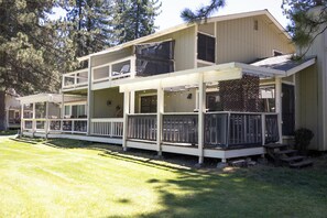 A two-story building with a balcony, a covered porch, and a fenced yard.