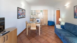 A compact living space with a dining area, kitchenette, and a sofa. - Relaxing Cristal Bedroom Apartment Sleeps Num1502 (Santa Teresa di Gallura)